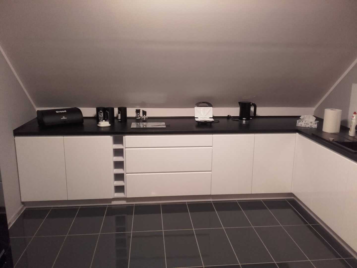 Kuchnia z zabudowanymi sprzętami na poddaszu